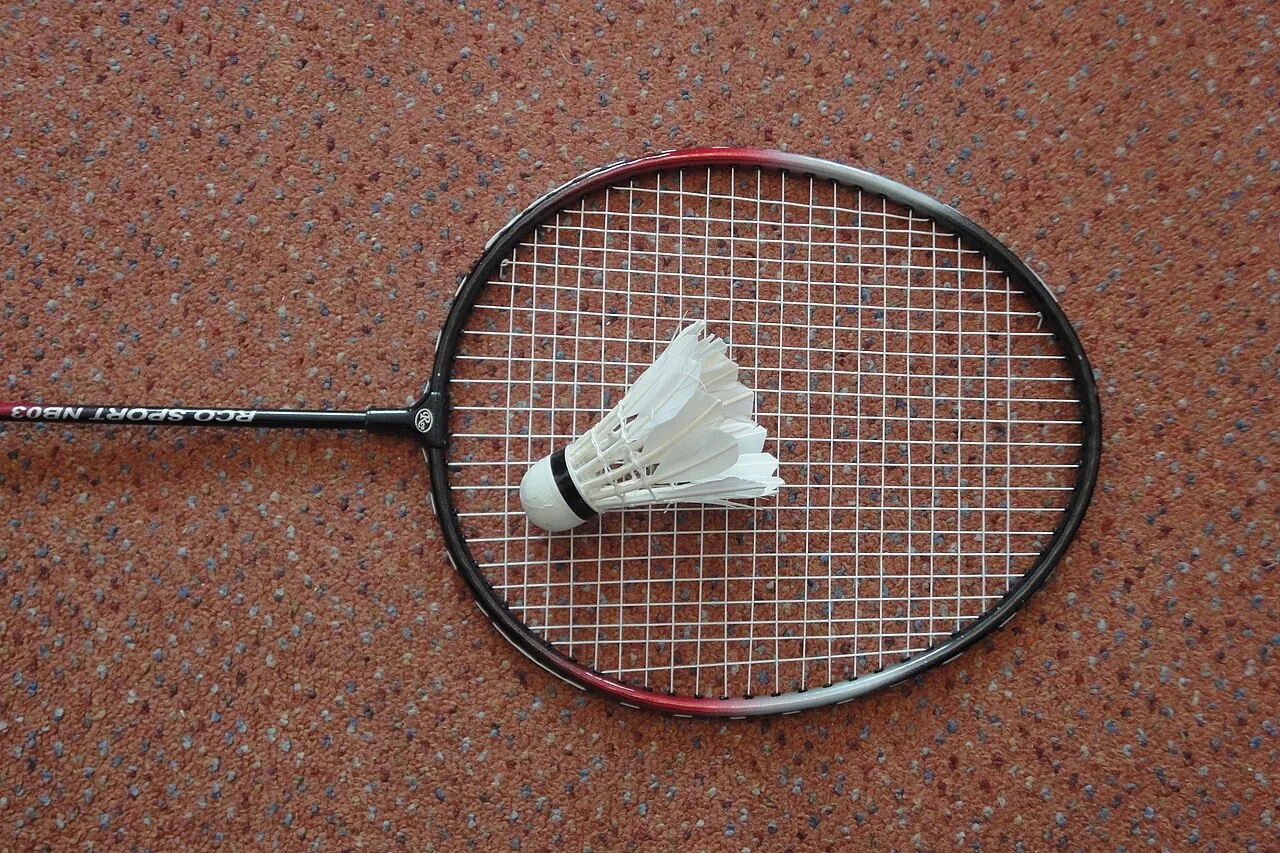 Raquette et volant de badminton posés sur le sol