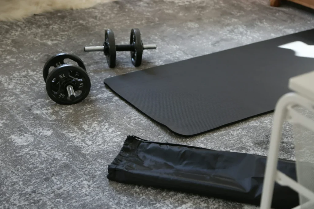 Haltères et tapis de sport posés au sol