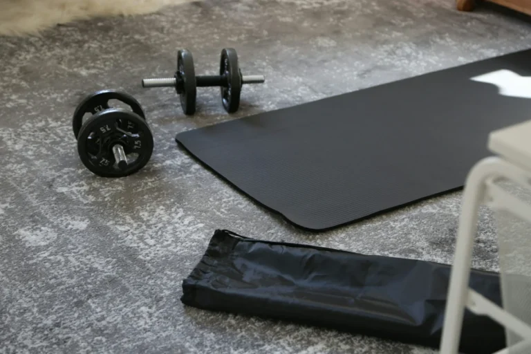 Haltères et tapis de sport posés au sol